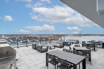 A rooftop patio with furniture and a view of the city
